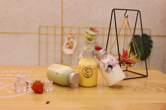 Botellas de plástico de té de leche con mango para beber con material y eficiencia