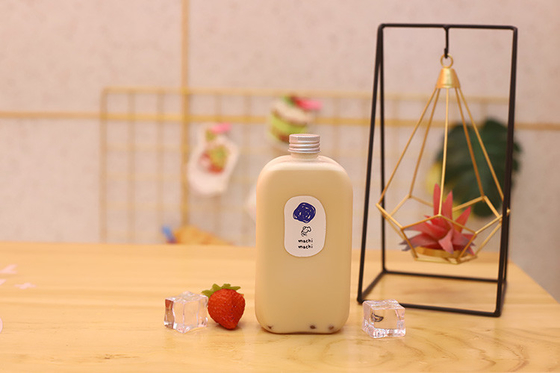 Manos de botellas de leche de té el mejor compañero para bebidas de tamaño medio
